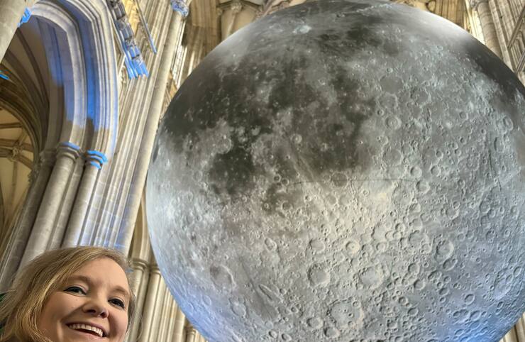 Kate smiling and pretending to hold the moon.