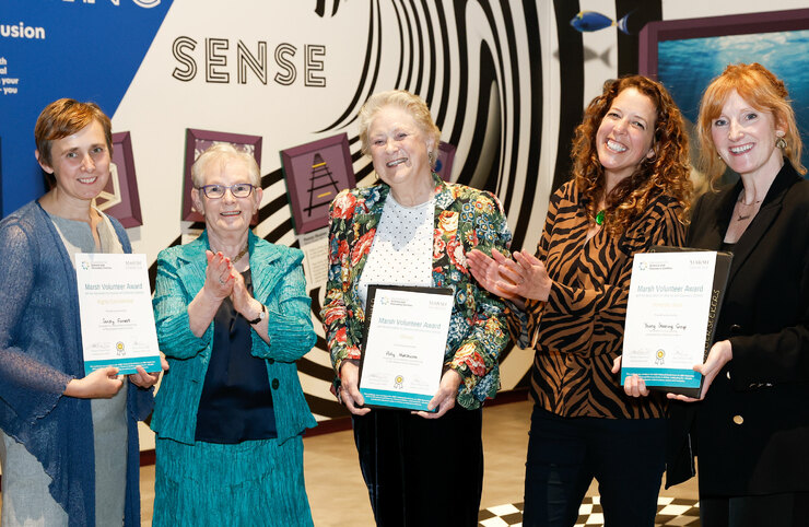 A group of people celebrate winning award certificates
