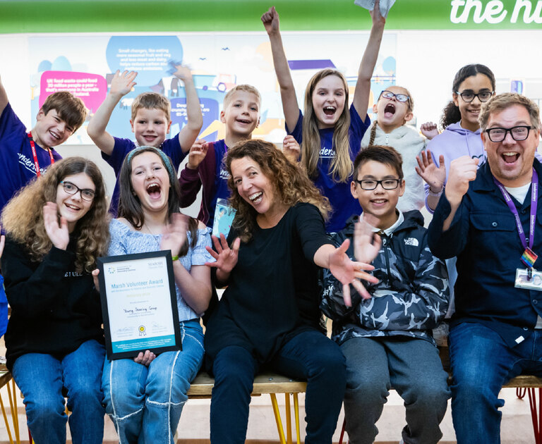 A group of children celebrate winning an award certificate