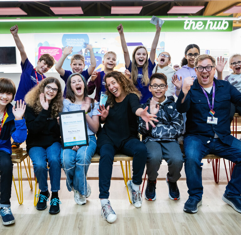A group of children celebrate winning an award certificate