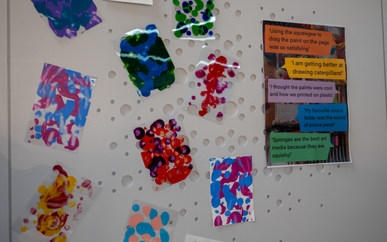 A selection of artwork is displayed on a white wall with a bubbly texture.