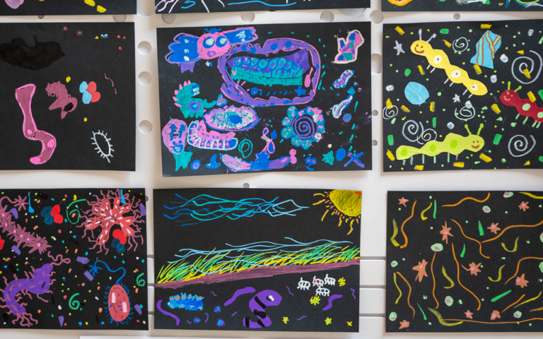 A close-up of some of the artwork displayed on a wall.