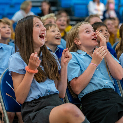 Two girls laugh at something off camera